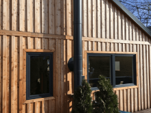 Fa épület antracit PVC ablakokkal